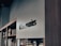 A modern retail store interior with a focus on minimalistic design. Shelves on the left side hold various boxed products, while a sleek, large sign reads 'Accessories' in bold letters. The lighting is soft, creating a calm ambiance.