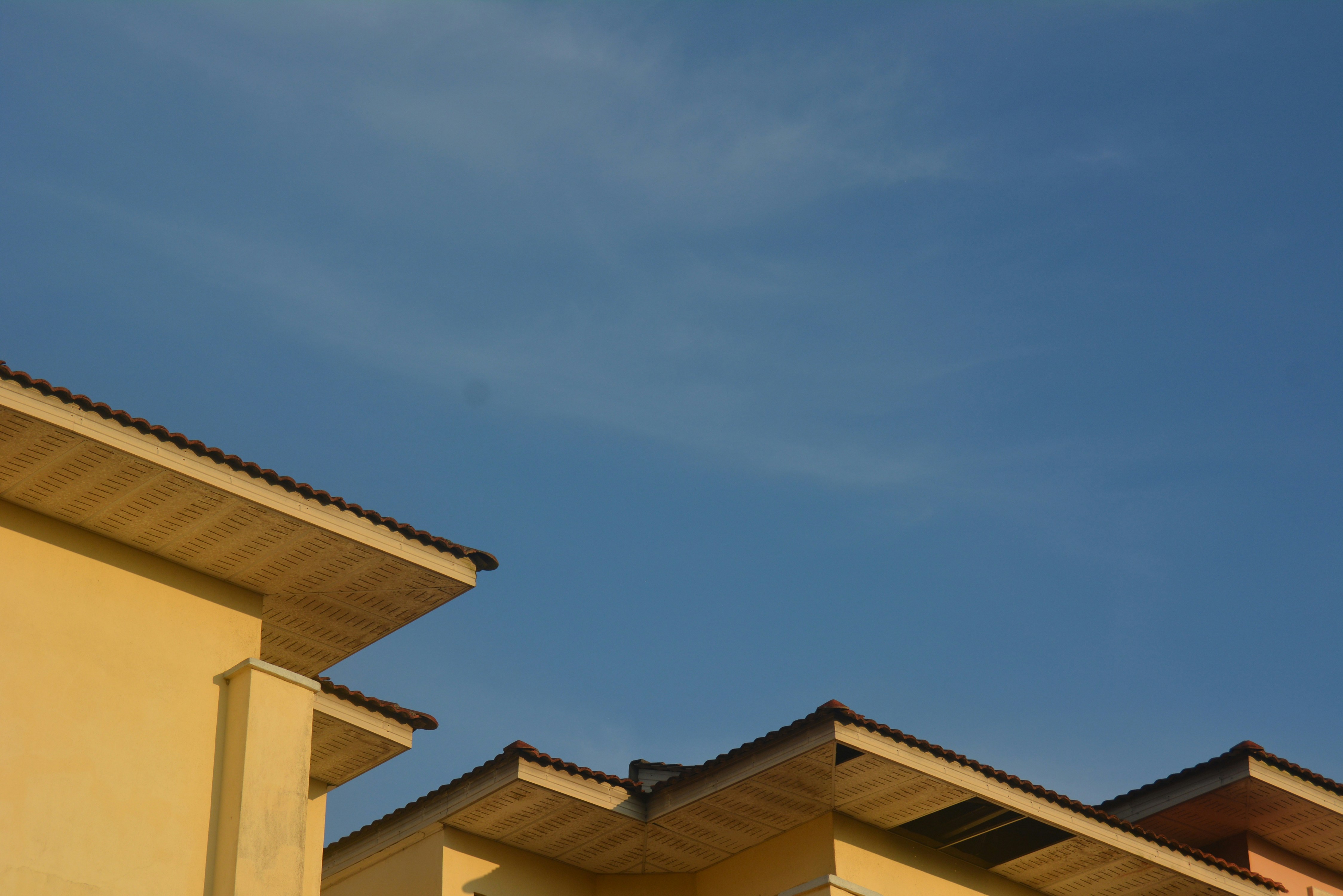 a row of yellow buildings with a blue sky in the background