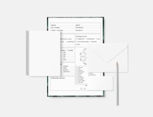 a notebook with a pen and paper on top of it