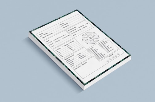 A stack of forms placed against a light blue background. Each form contains various sections including checkboxes, a circular diagram, tables, and lines for handwritten information. The forms also have a decorative border featuring green patterns.