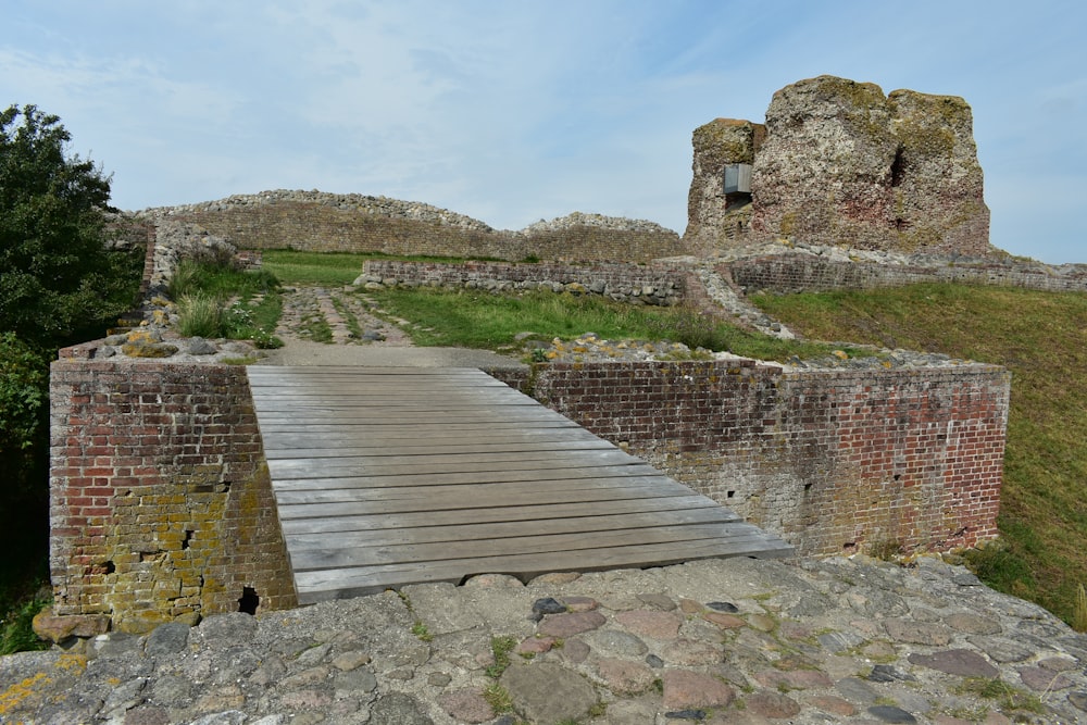 a wooden walkway leading to a stone castle