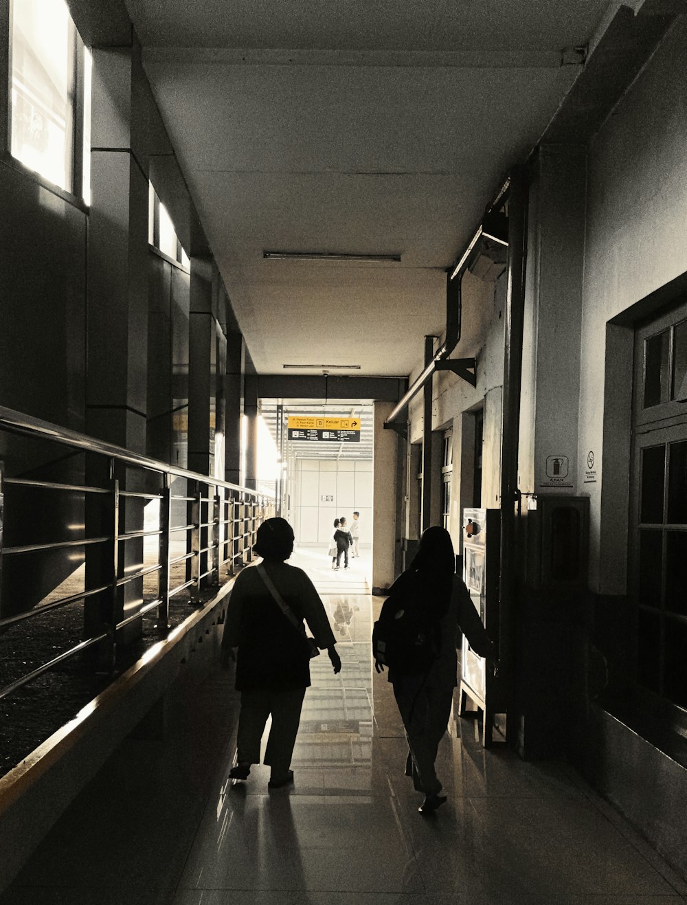 a couple of people walking down a hallway