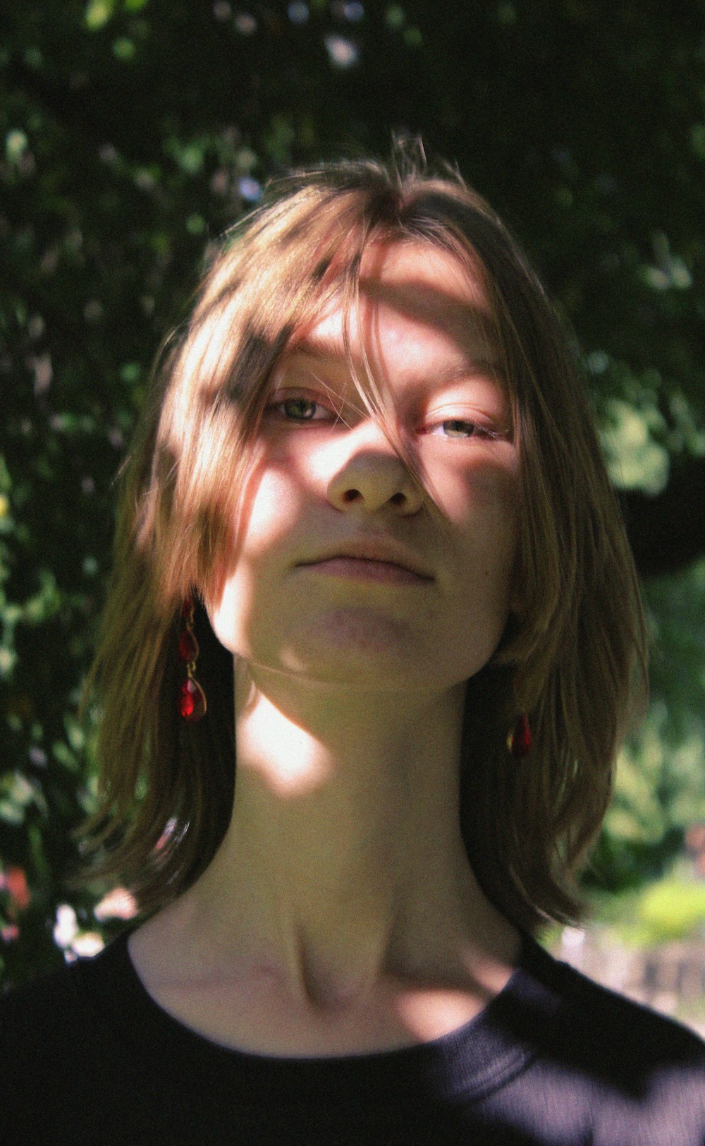 a woman standing in front of a tree with her eyes closed