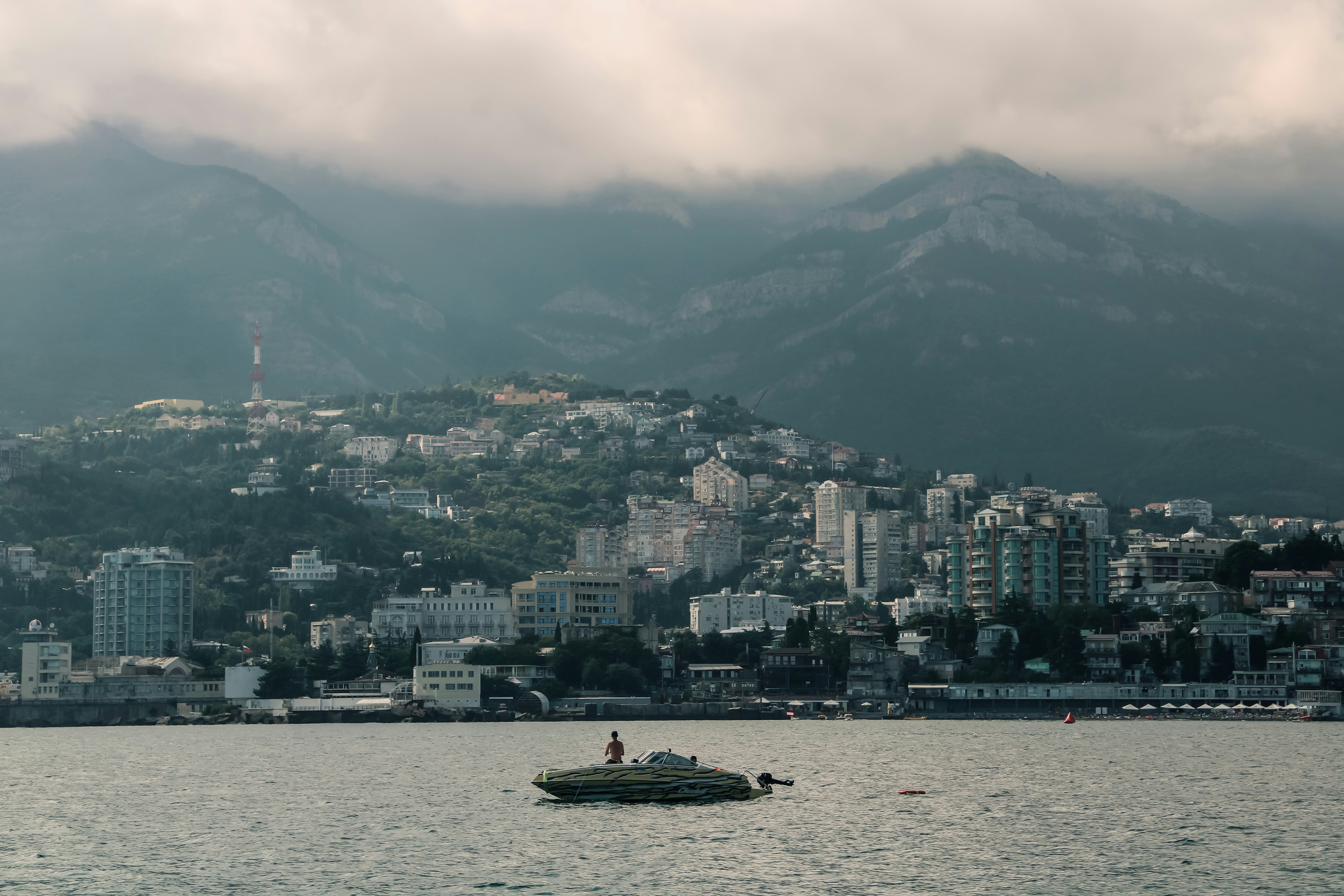 a boat in the water with a city in the background, 