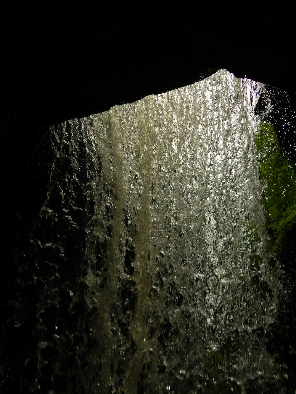 a view of water coming out of a cave