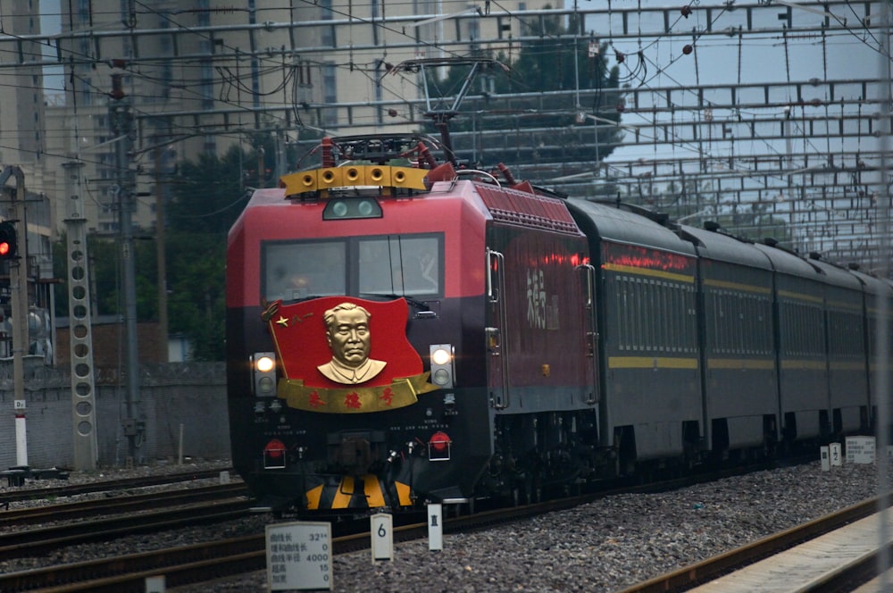 a red and black train traveling down train tracks