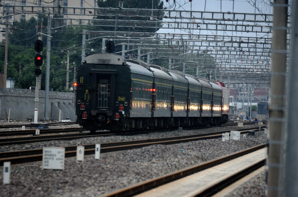 a train traveling down train tracks next to a traffic light