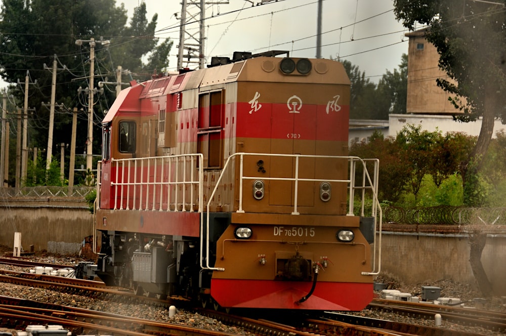 a red and brown train traveling down train tracks