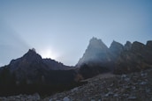 Sunrise over alpine peaks with hikers preparing for a day of adventure.