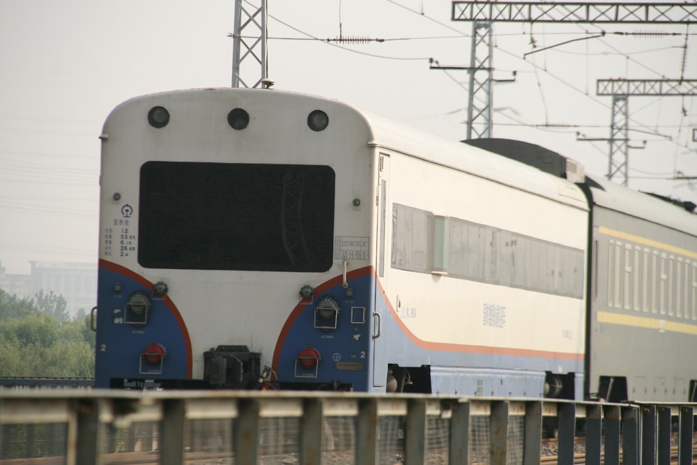 um trem viajando pelos trilhos do trem ao lado de uma floresta