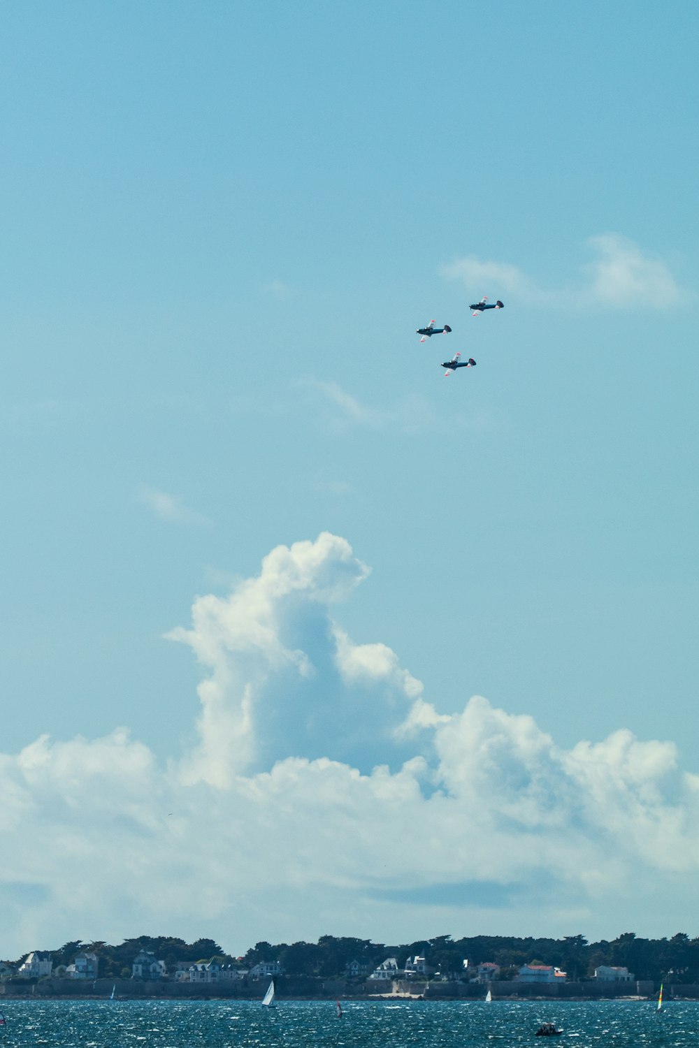 a group of planes flying over a body of water