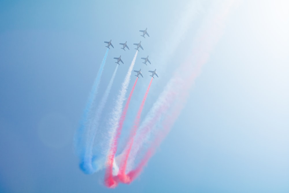 a group of jets flying through a blue sky