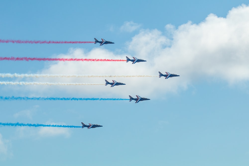 a group of fighter jets flying through a blue sky