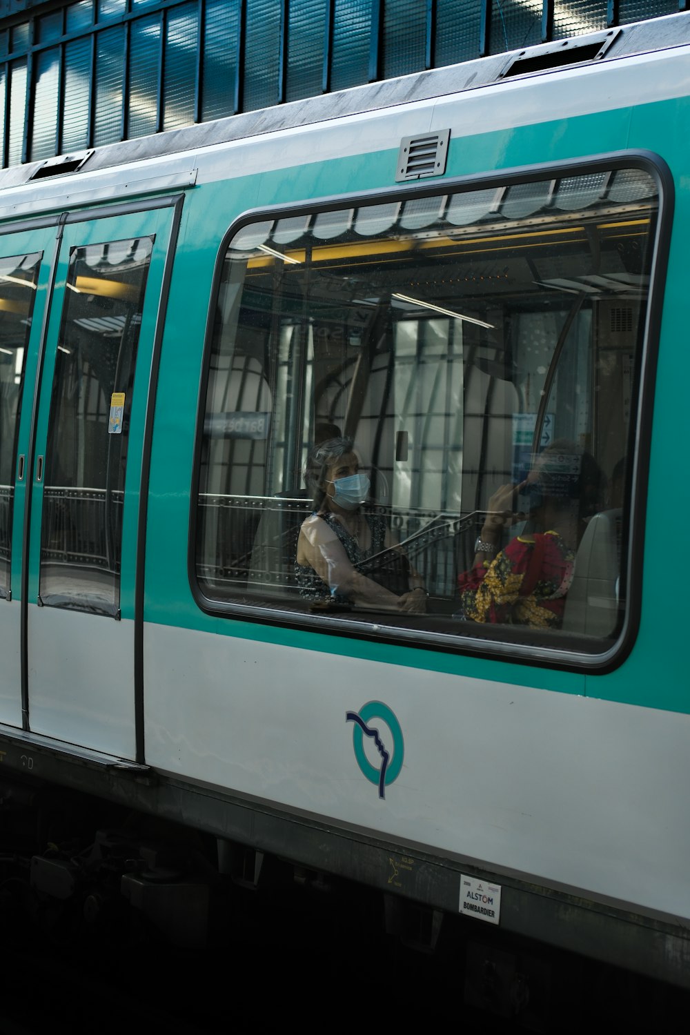 a green and white train traveling down train tracks