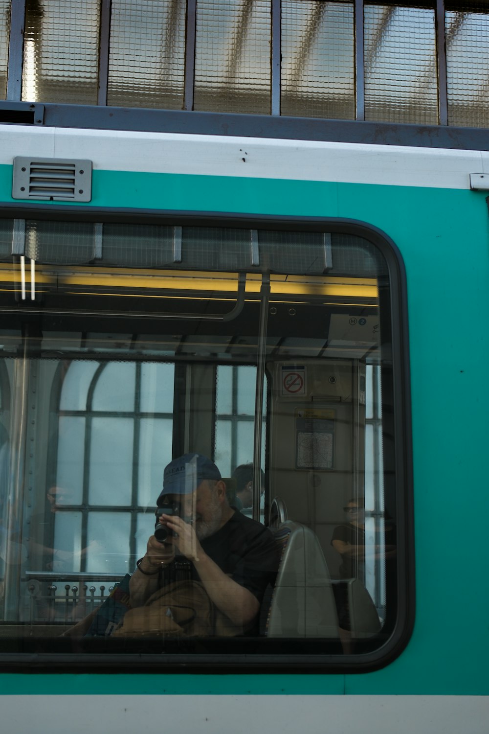 a man taking a picture of himself in the window of a train