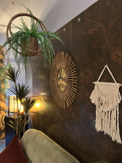 Brightly lit cozy room corner featuring a large macramé wall hanging with natural textures