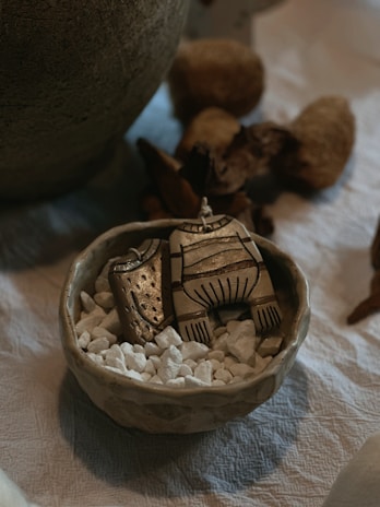 Mixed media piece combining ceramics, metal accents, and wood elements in harmony.