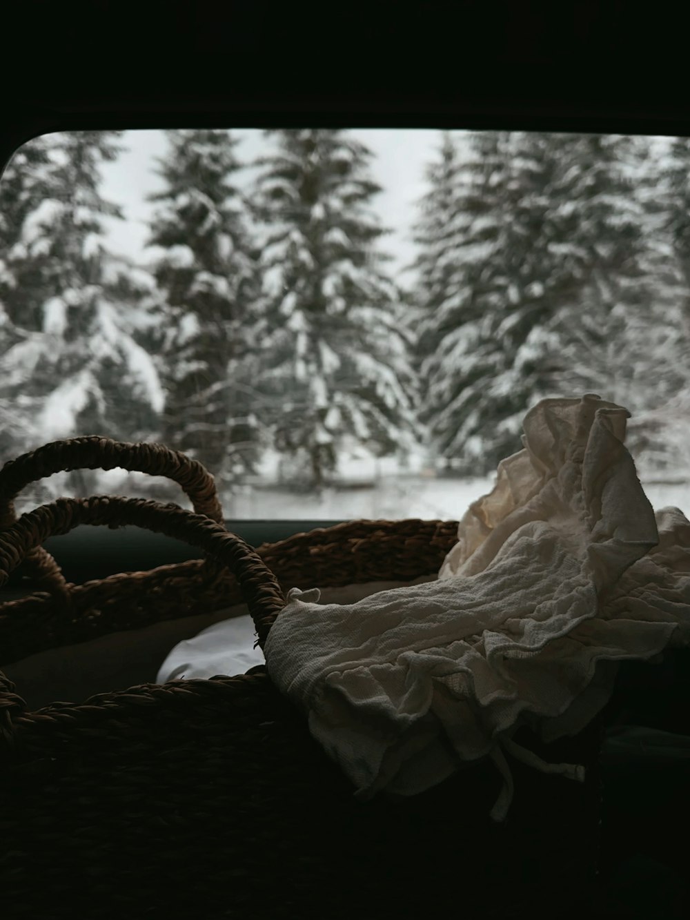 a basket with a cloth on it sitting in front of a window