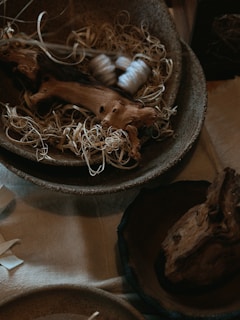 A rustic wooden bowl featuring delicate yarn accents.