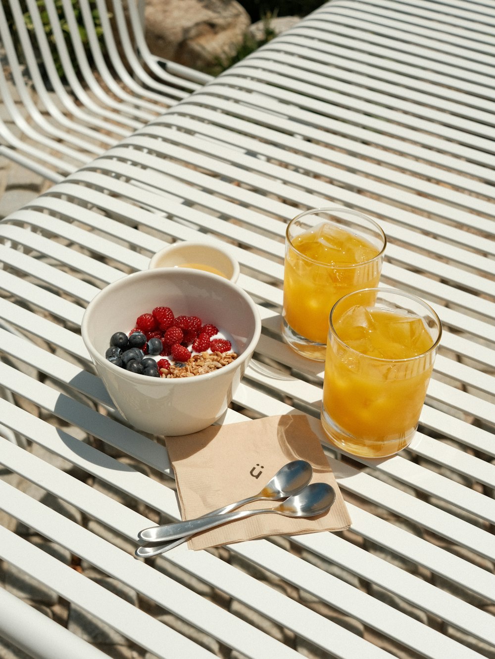 a bowl of fruit and two glasses of orange juice