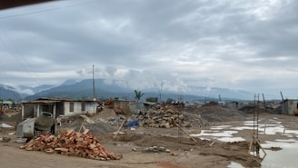A variety of construction materials including bricks, cement bags, and gravel piles.