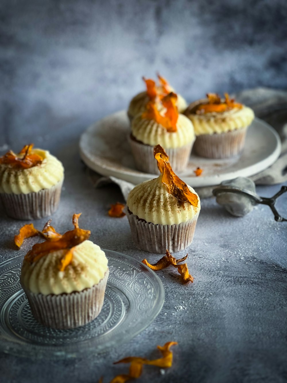 a plate of cupcakes with orange zest on top