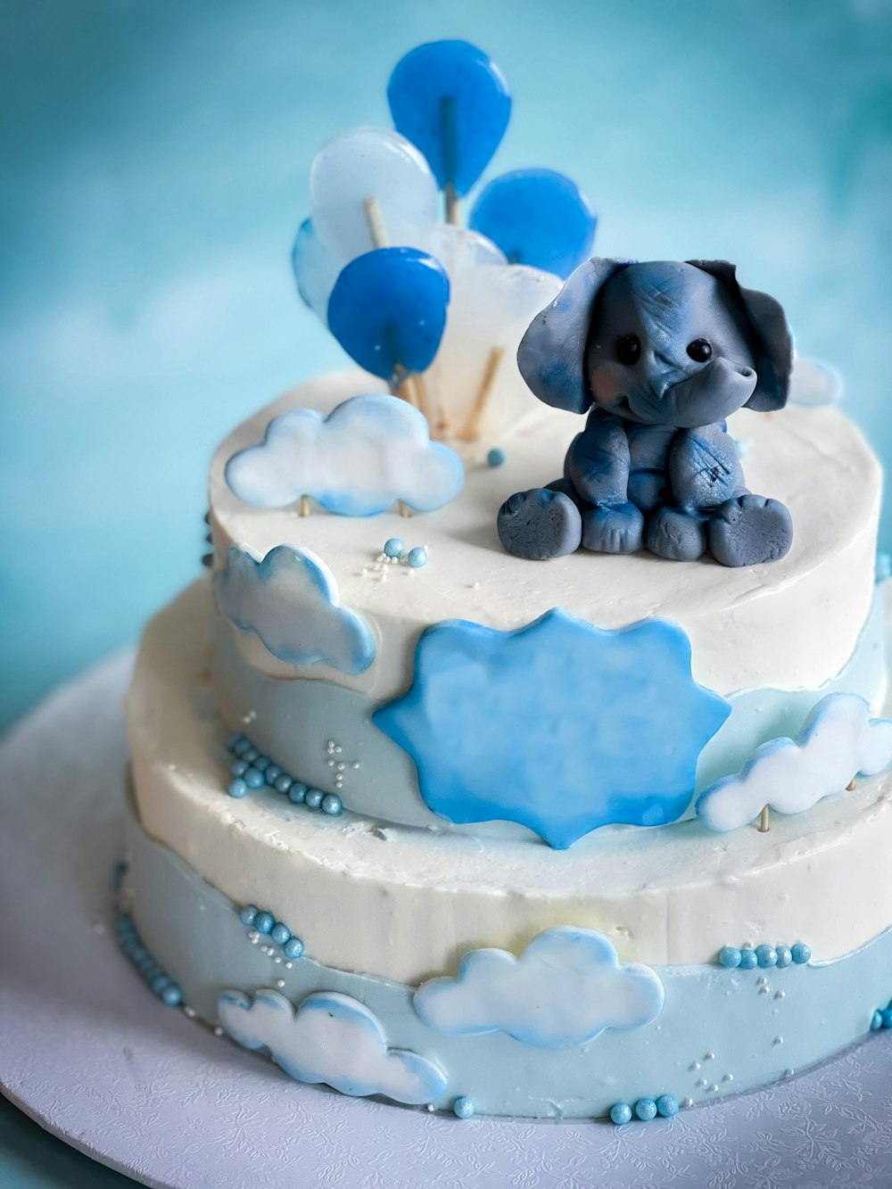 a blue and white cake with an elephant on top