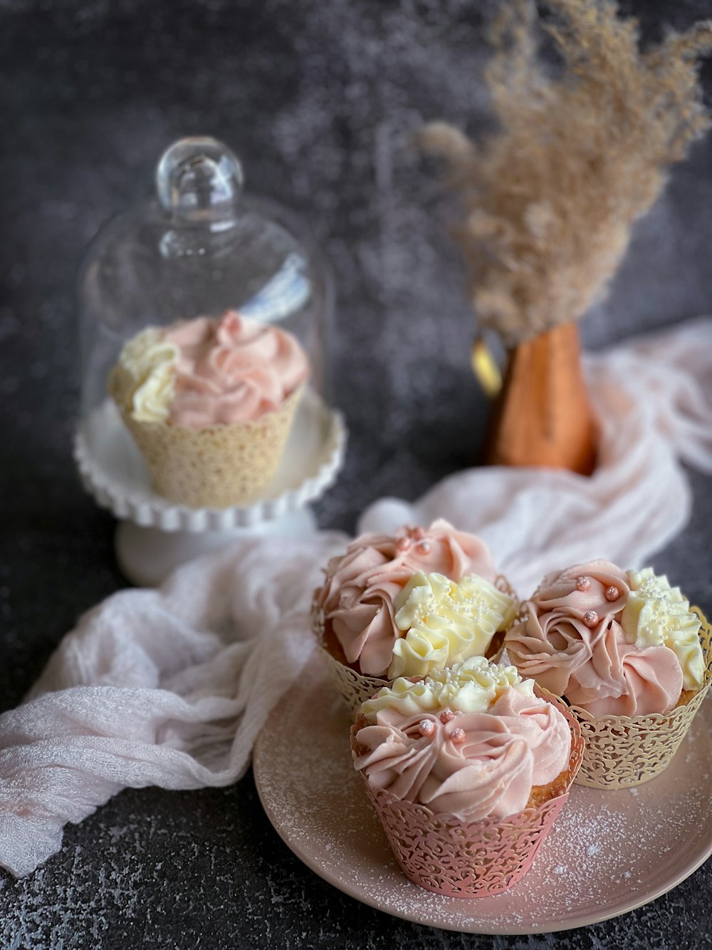 three cupcakes with frosting on a plate