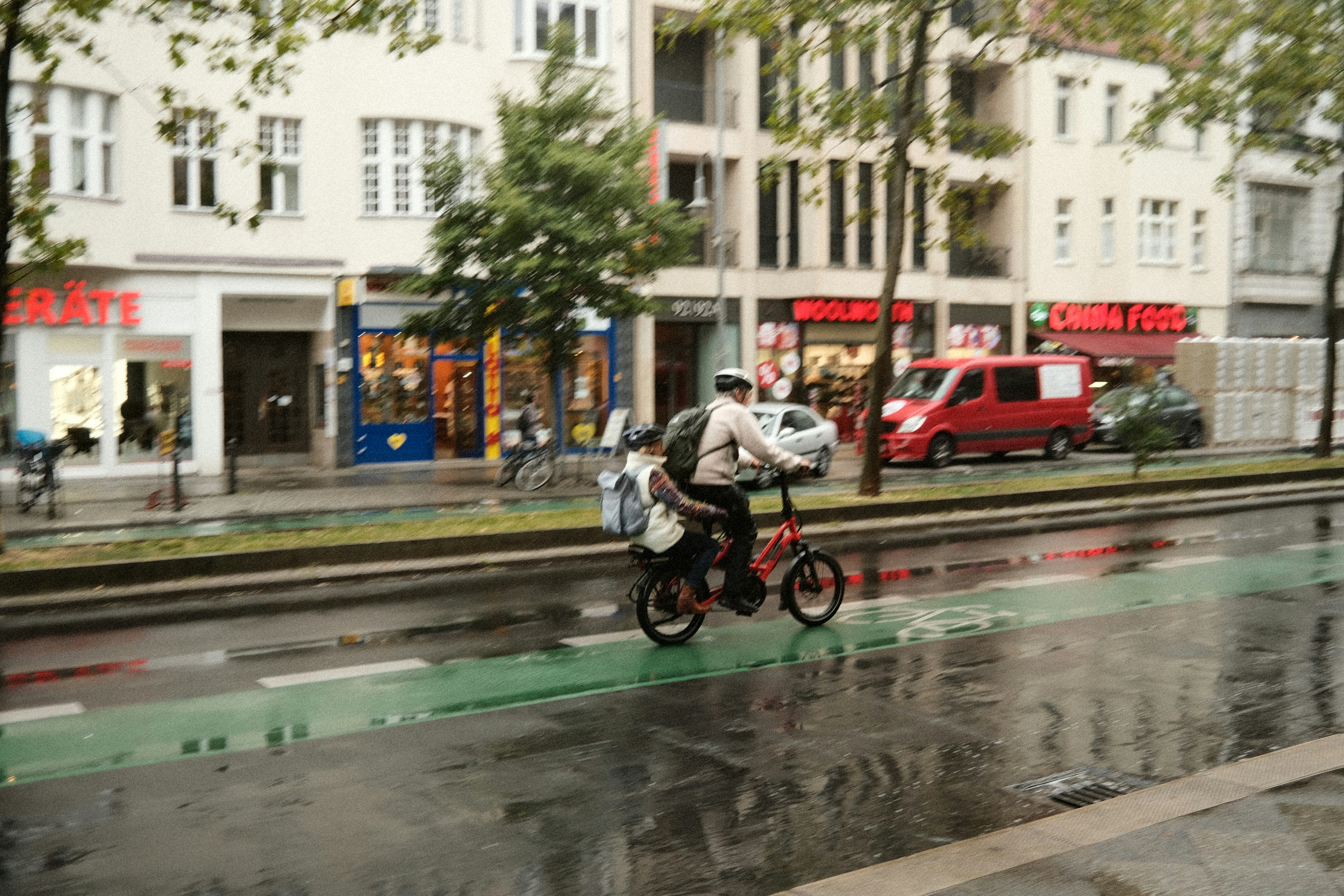 a man riding a bike down a rain soaked street