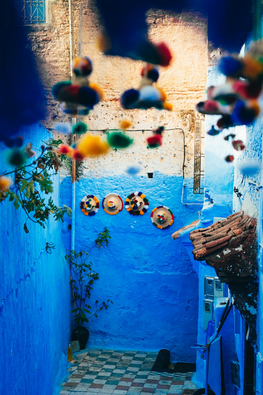 a narrow alleyway with blue walls and a tiled floor