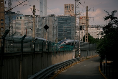 A sleek Acela Express train speeding along the Northeast rail line with city skylines in the background.