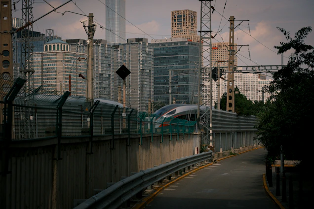 A sleek, modern train speeding through a vibrant cityscape under a glowing aurora-lit sky.