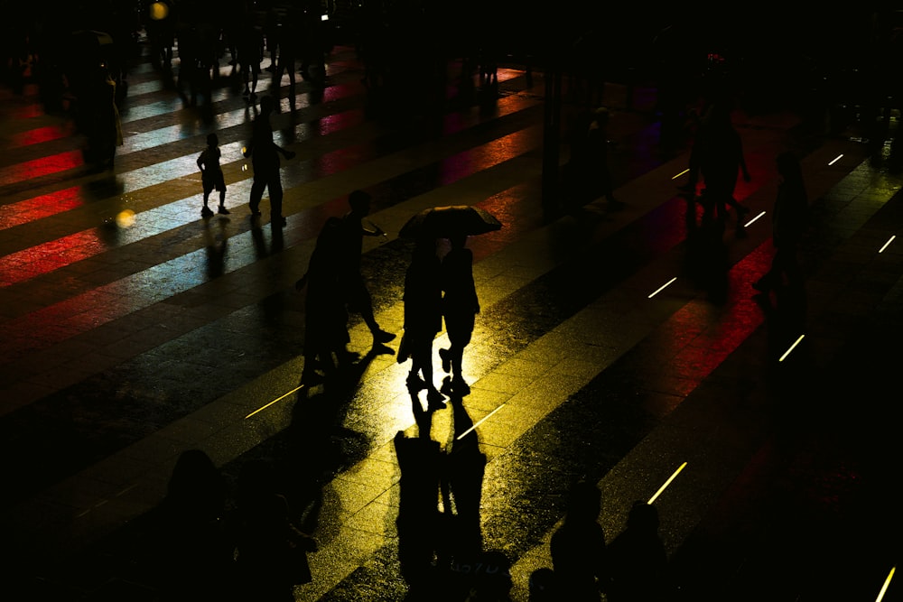 um grupo de pessoas caminhando por uma rua à noite