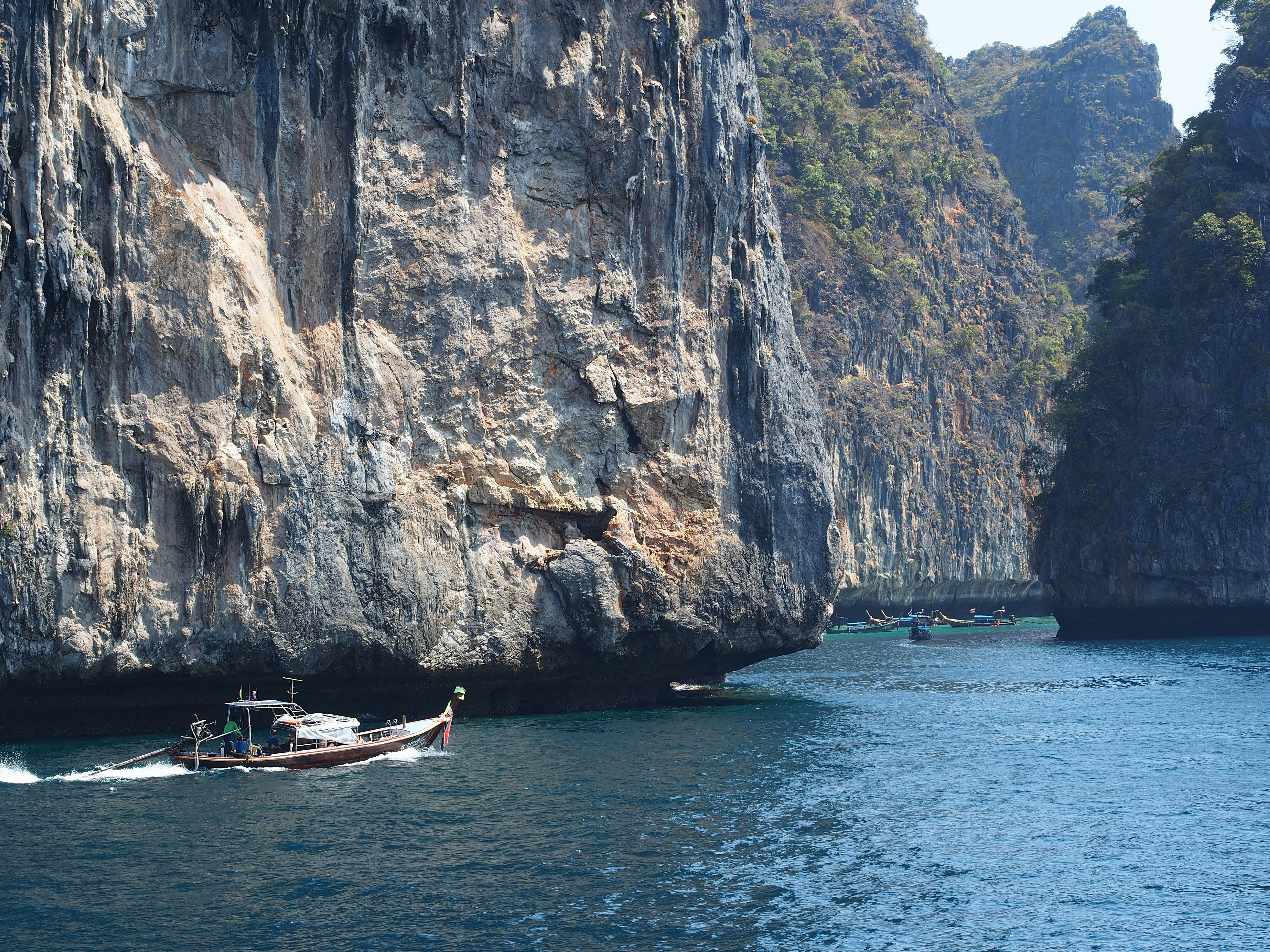 a boat traveling through a body of water near a mountain