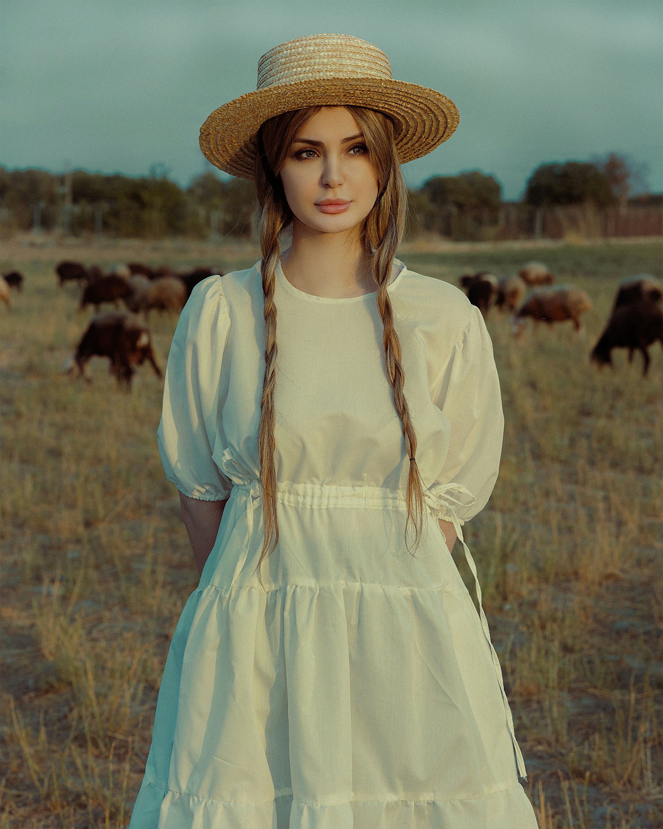a woman wearing a straw hat standing in a field