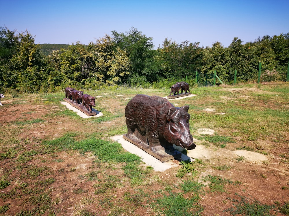 a group of statues of animals in a field
