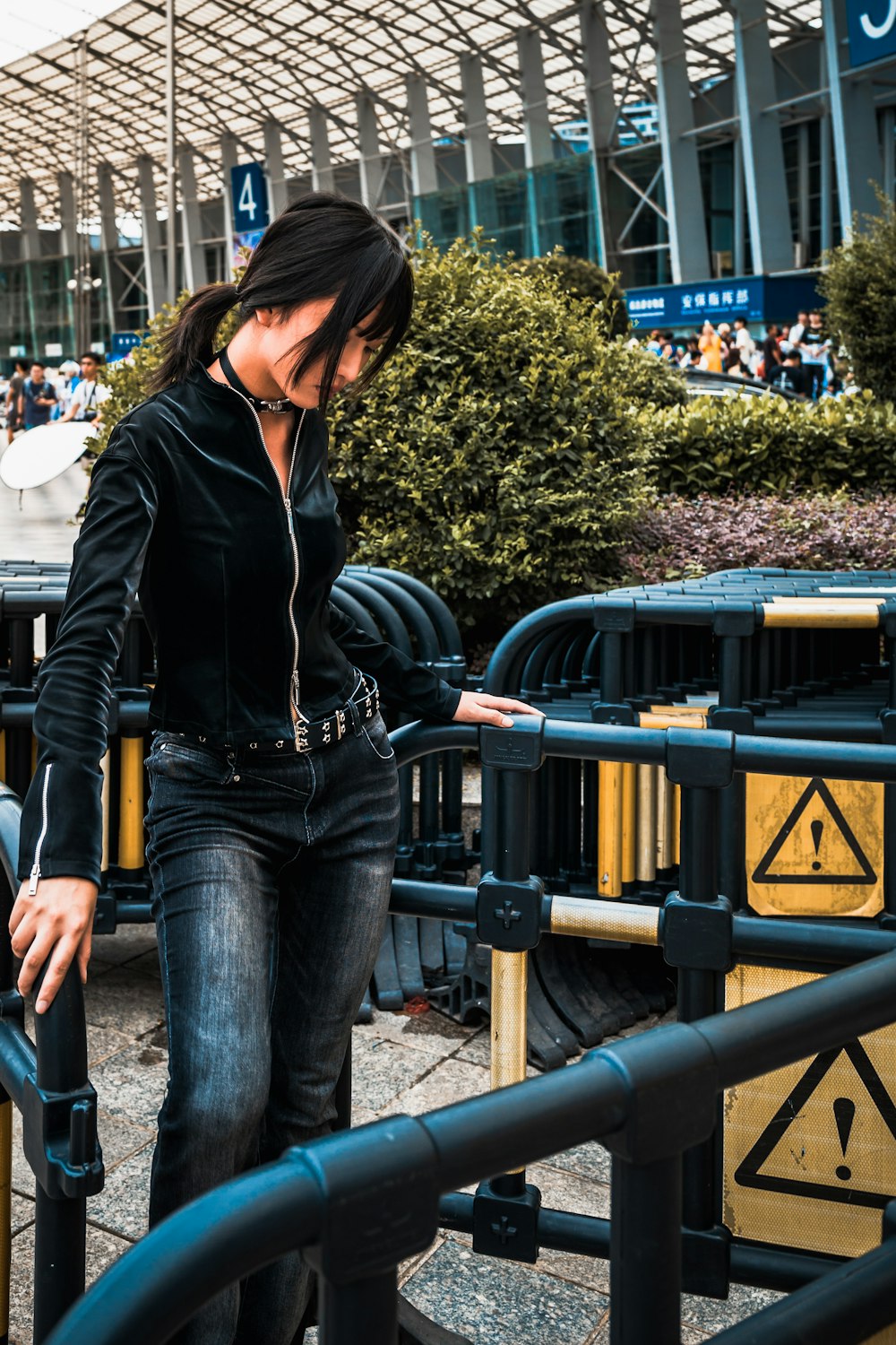 a woman wearing headphones is leaning on a railing