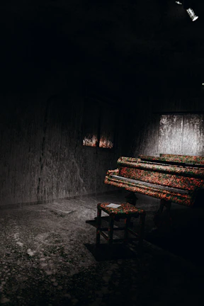Warmly lit corner of the studio with a vintage piano and soft indigo walls.
