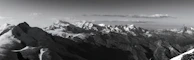 A panoramic view of the nearby mountain range with clouds gently resting on the peaks.