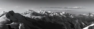 A panoramic view of the nearby mountain range with clouds gently resting on the peaks.