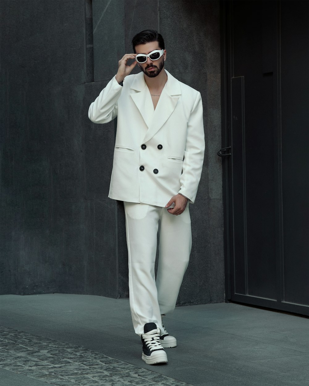 a man in a white suit and sunglasses