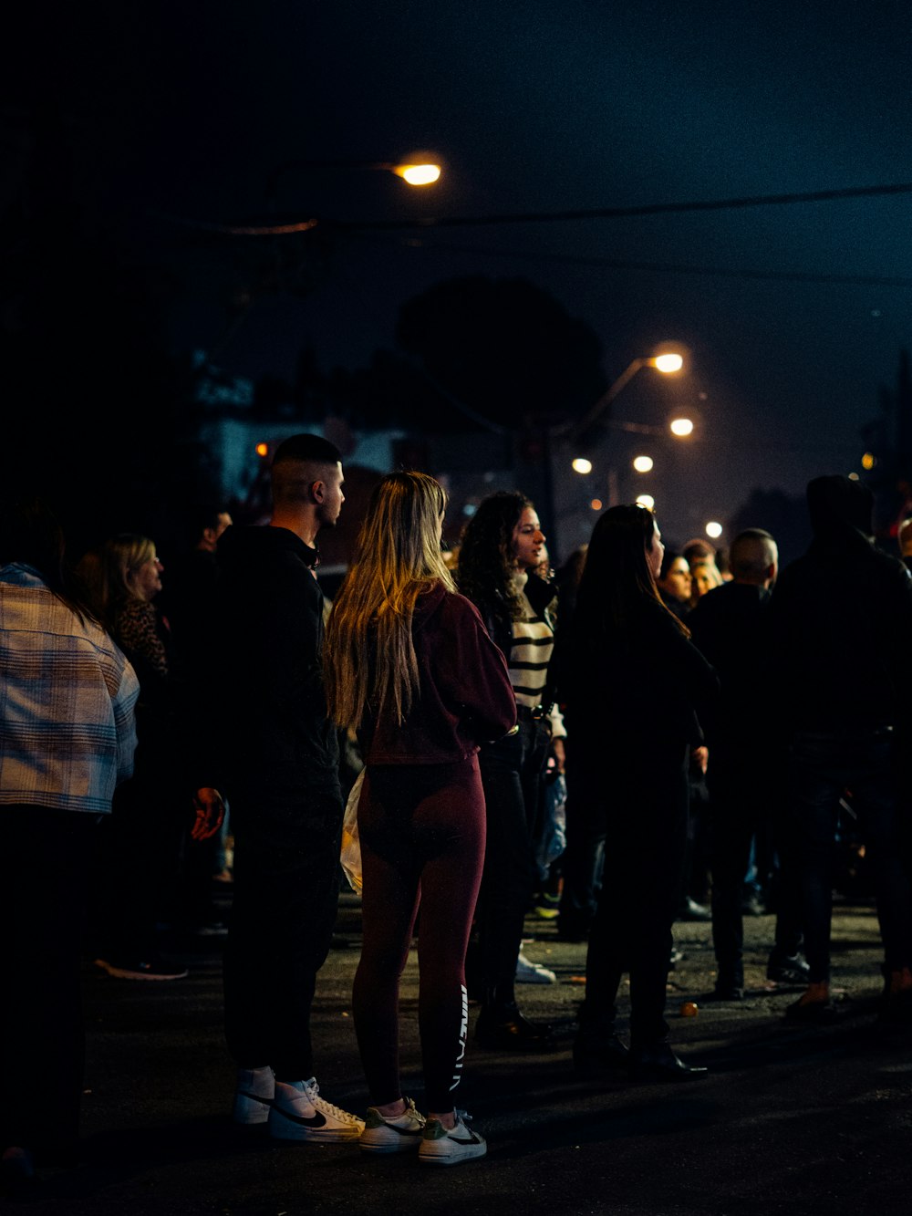 a group of people standing on a street at night