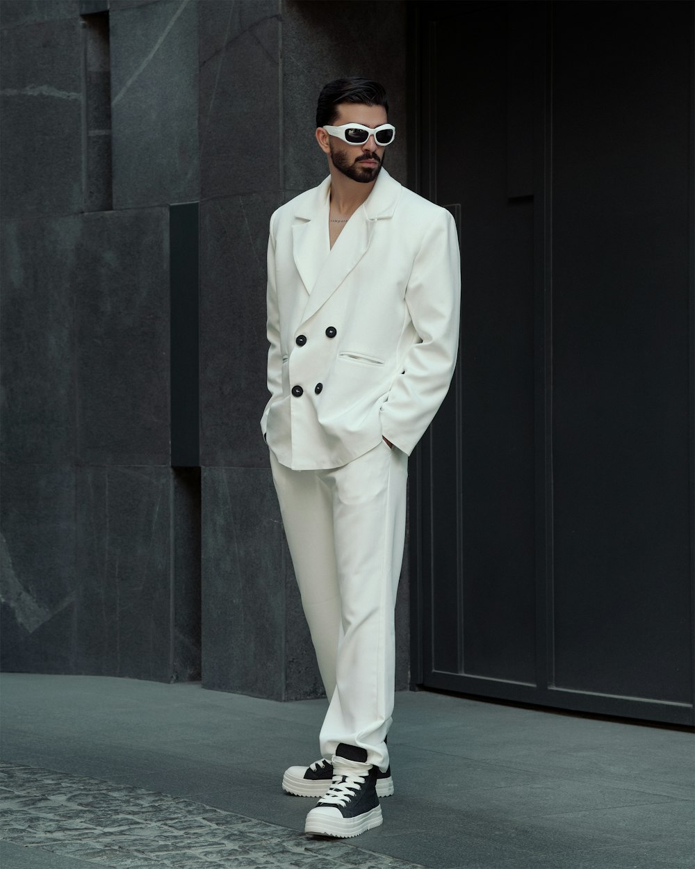 a man in a white suit and sunglasses