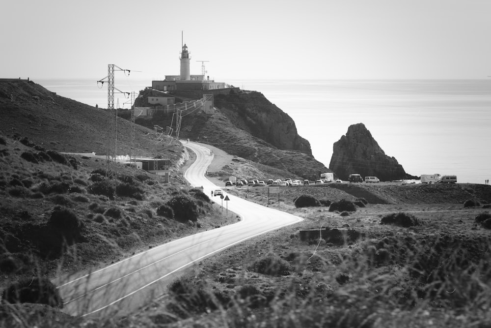 a black and white photo of a road near the ocean