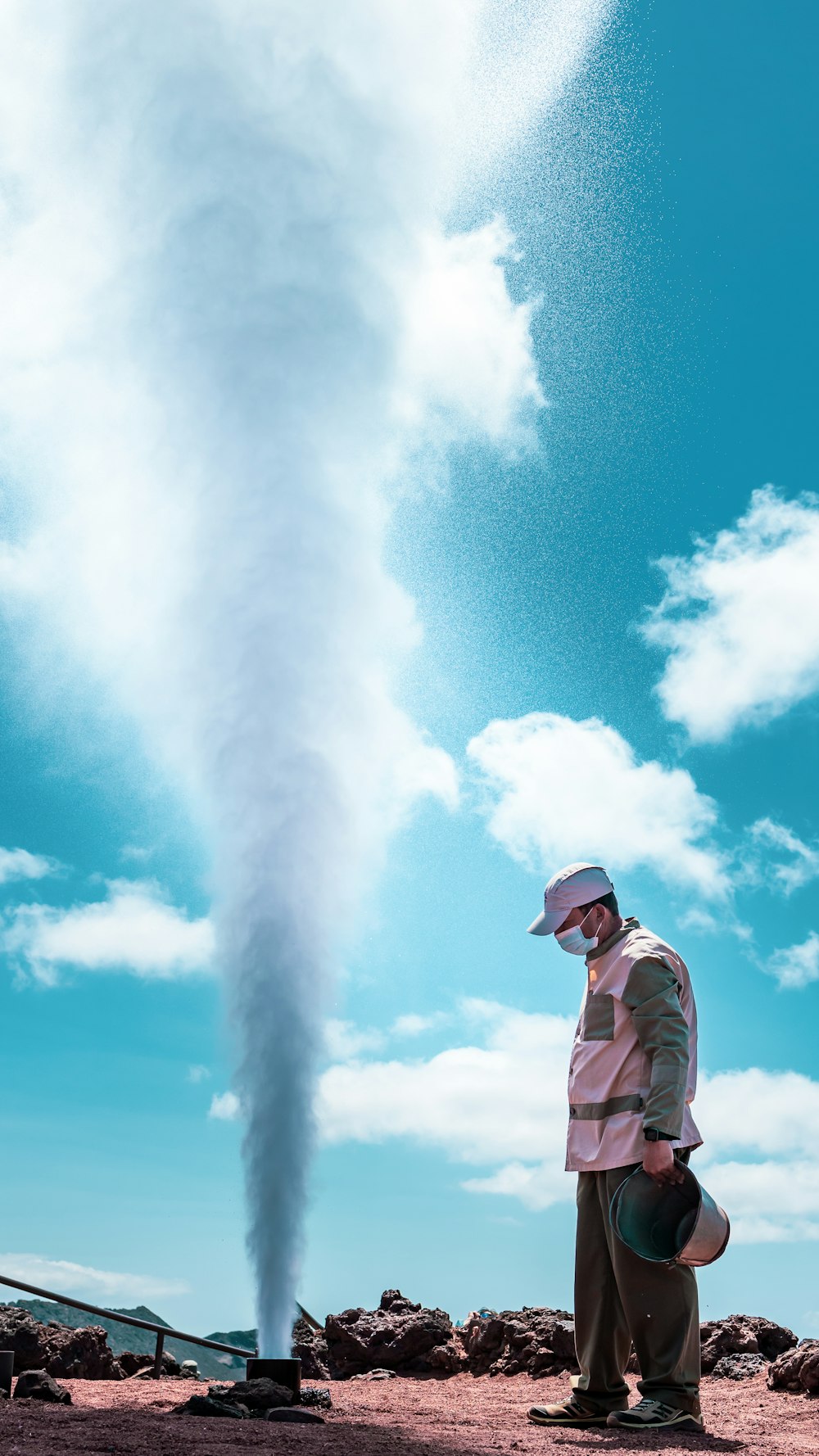a man standing in front of a smoke stack