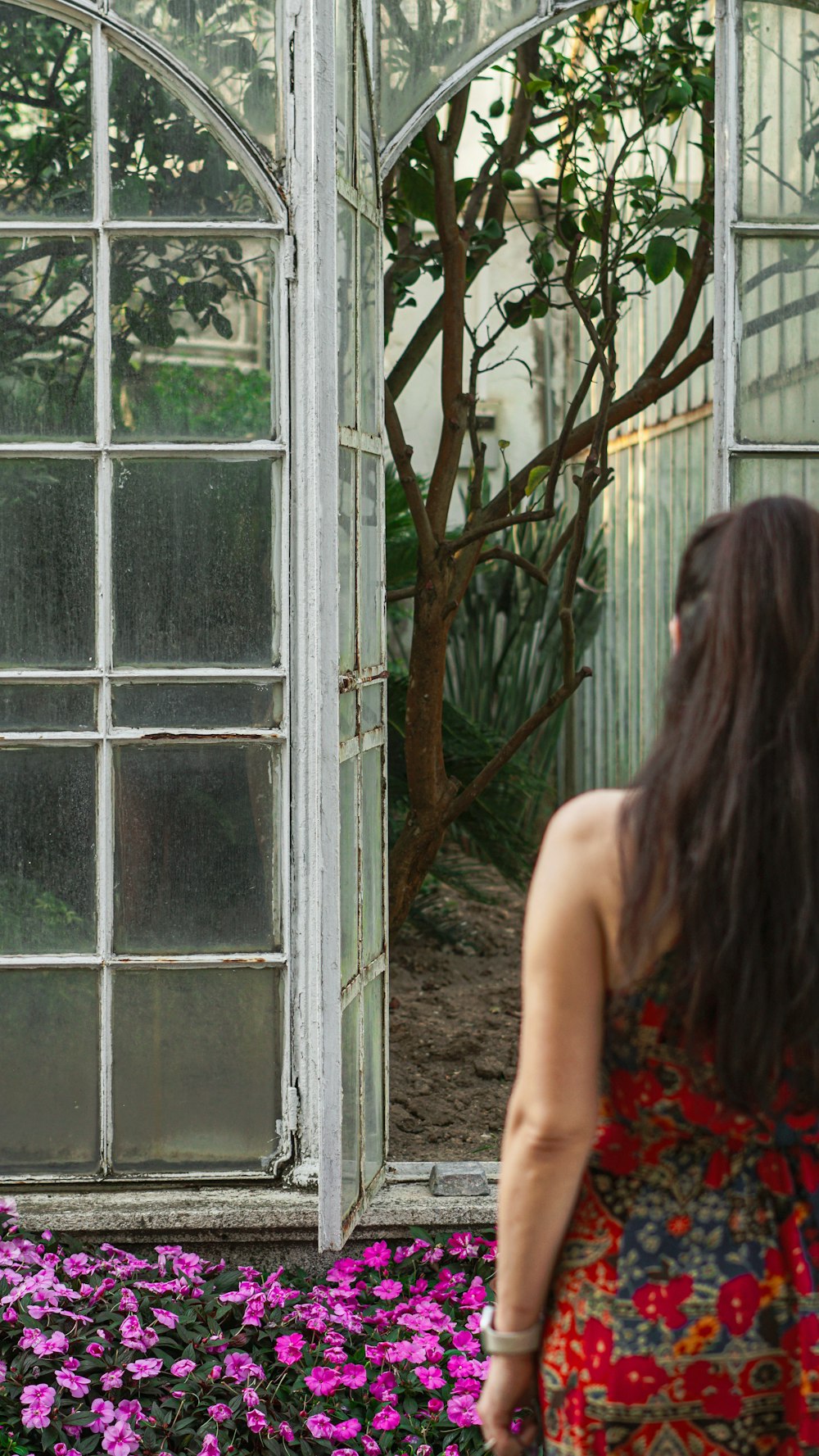 a woman standing in front of a mirror in a garden