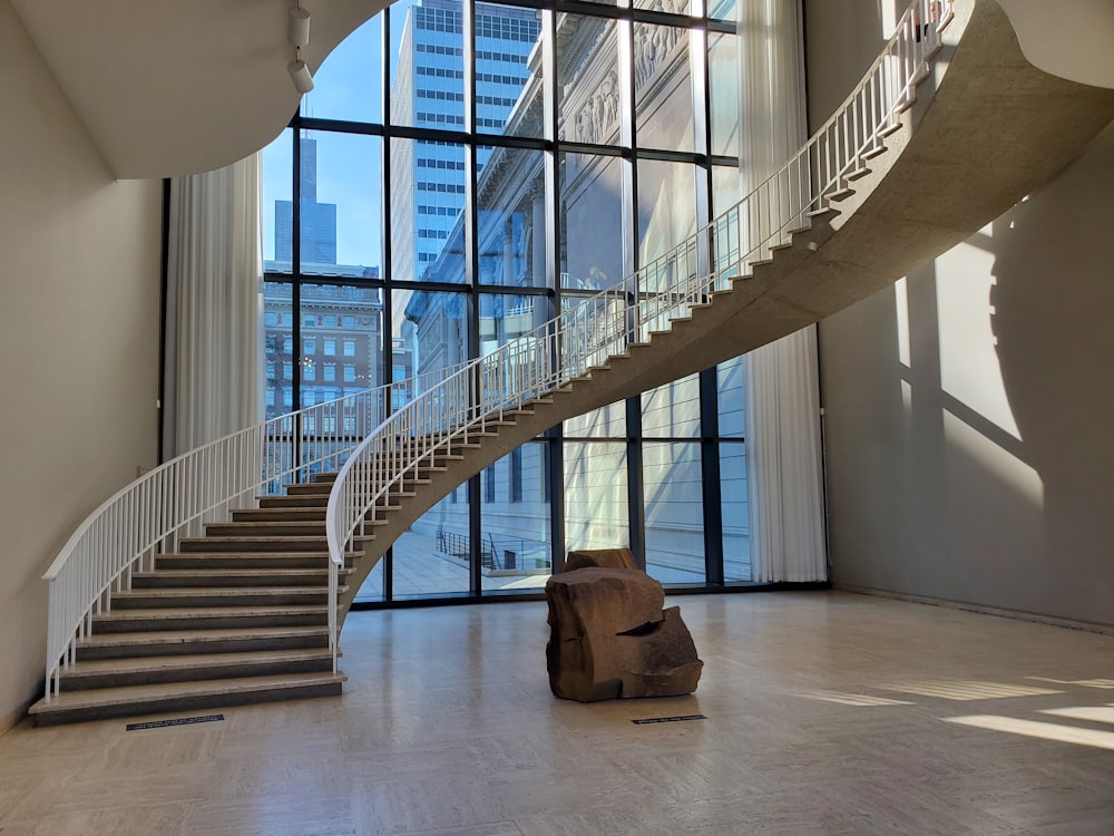 a spiral staircase in a building with large windows