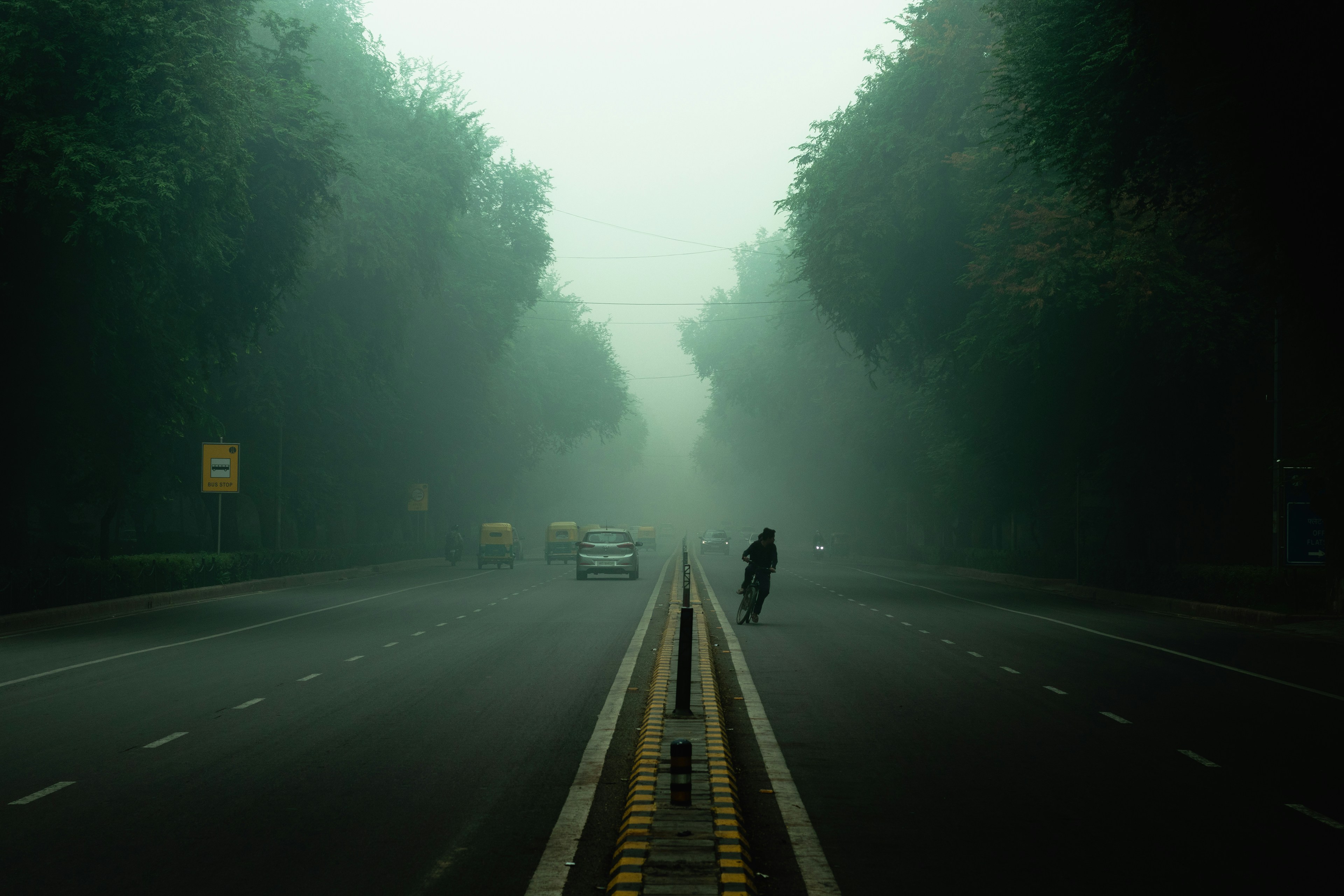 a person riding a bike on a foggy road