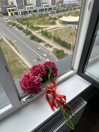 A cheerful delivery person handing over a colorful bouquet outside a classic Chicago building near South LaSalle.