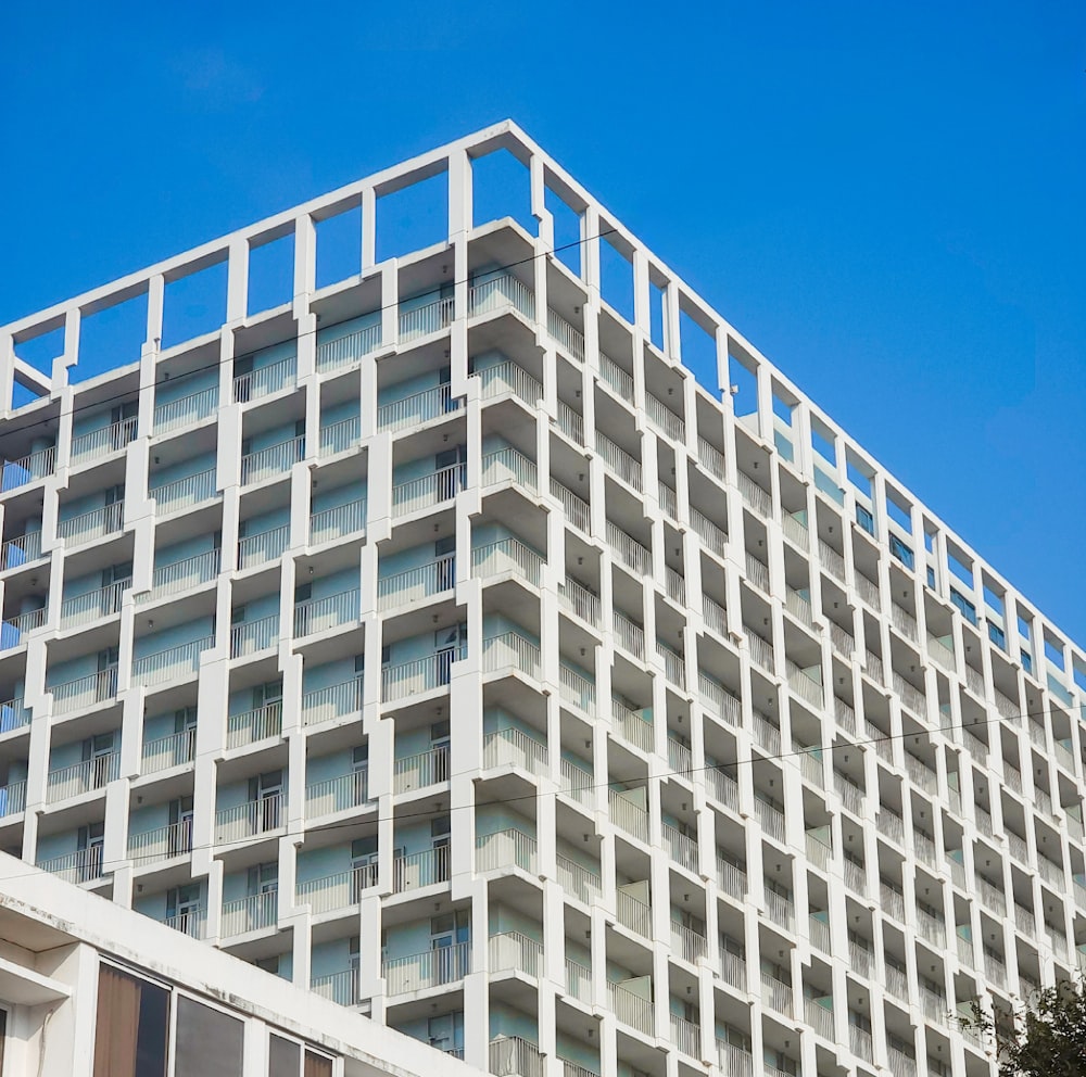 a tall white building with balconies on top of it